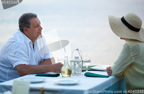 Image of Middle-aged couple sitting waiting for a meal