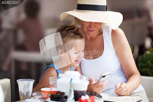 Image of Grandmother and Grandson Using Cell Phone Together