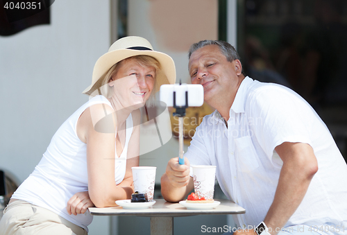 Image of Adult couple taking selfie with cell phone