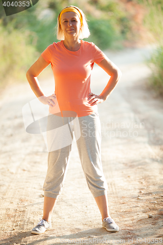 Image of Mature Woman Standing with Hands on Hips on Road