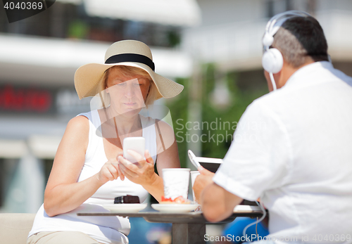 Image of Adult couple at table using devices