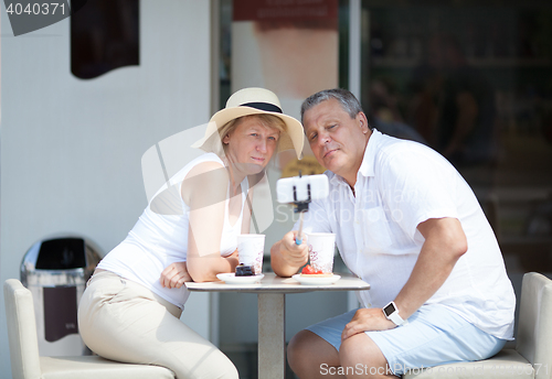 Image of Adult couple taking selfie with cell phone