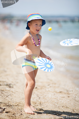 Image of Young Boy Playing Paddle Ball on Sunny Beach