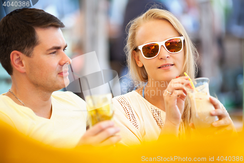 Image of Young couple relaxing with refreshing drinks