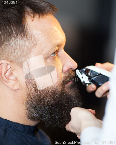 Image of Man having his mustache trimmed at a barber