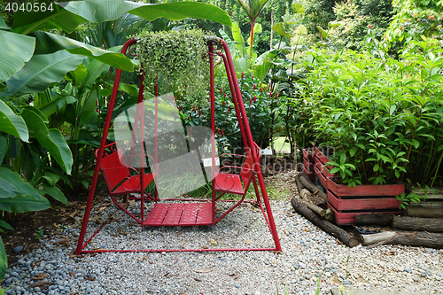 Image of Red swing hanging in garden