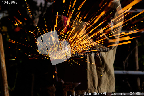 Image of Worker cutting metal with grinder. Sparks while grinding iron