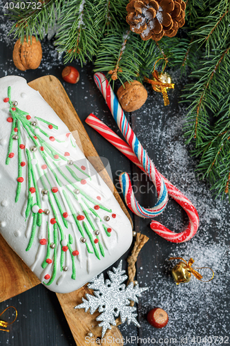 Image of Cupcake with Christmas decorations, candies and spruce branches.