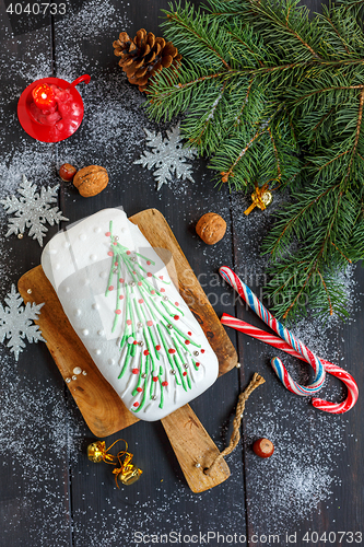 Image of Christmas cake, candy, snowflakes and a burning candle.