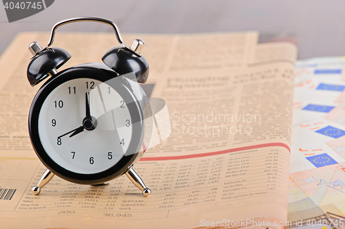 Image of Close-up of clock, Euro banknotes and newspaper