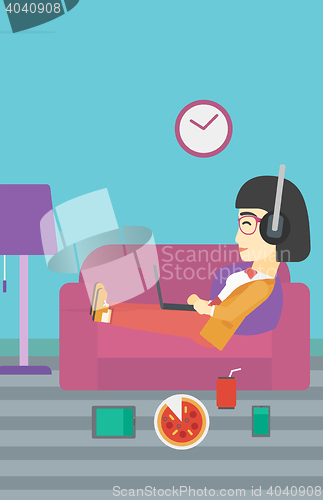 Image of Woman lying on sofa with many gadgets.