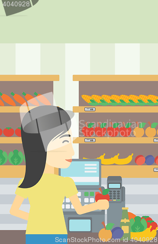 Image of Cashier standing at the checkout in supermarket.