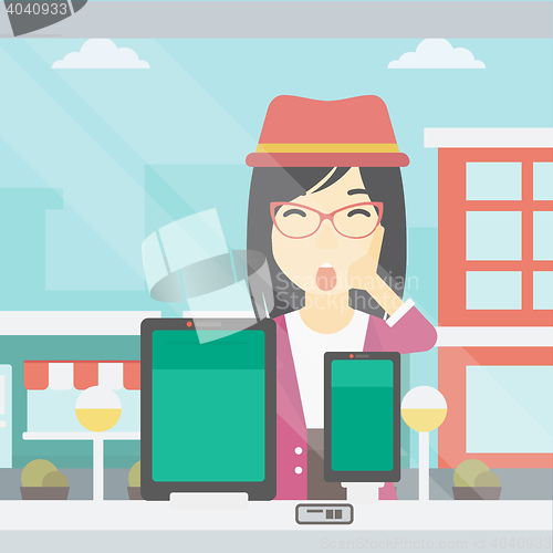 Image of Woman looking at digital tablet and smartphone.