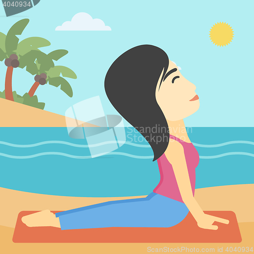 Image of Woman practicing yoga upward dog pose on beach.