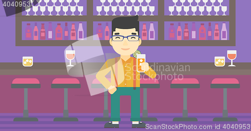 Image of Man drinking orange cocktail at the bar.