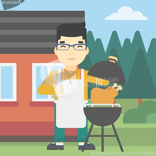 Image of Man cooking chicken on barbecue grill.