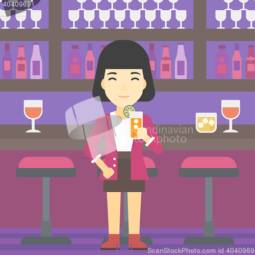 Image of Woman drinking orange cocktail at the bar.