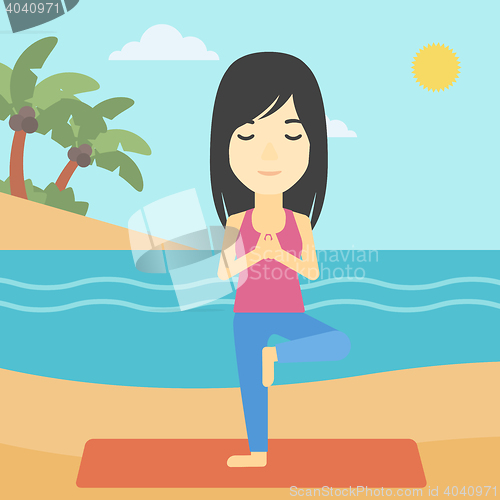 Image of Woman practicing yoga tree pose on the beach.