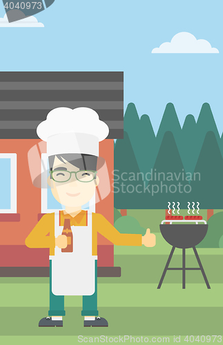 Image of Man cooking meat on gas barbecue grill.