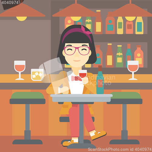 Image of Woman drinking wine at restaurant.