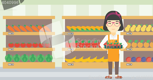 Image of Supermarket worker with box full of apples.