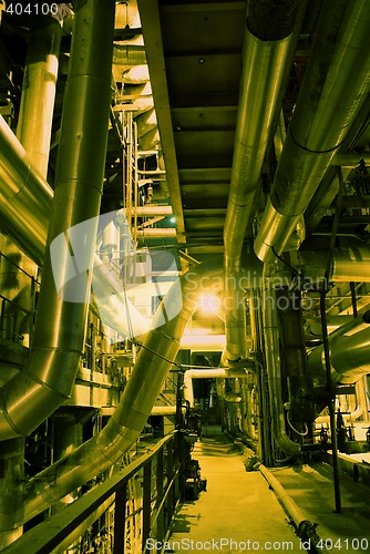 Image of Pipes, tubes, machinery and steam turbine at a power plant