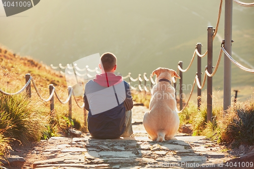 Image of Man with dog on the trip in the mountains