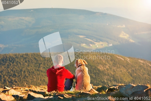 Image of Man with dog on the trip in the mountains