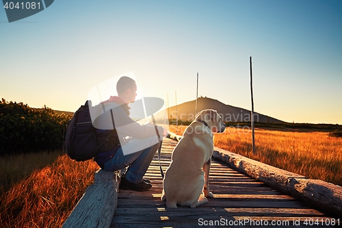 Image of Man with dog on the trip in the mountains 