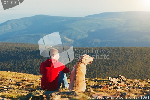 Image of Man with dog on the trip in the mountains