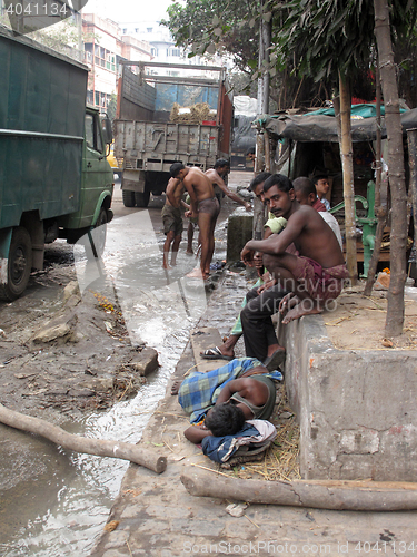 Image of Streets of Kolkata. Indian people wash themselves on a street