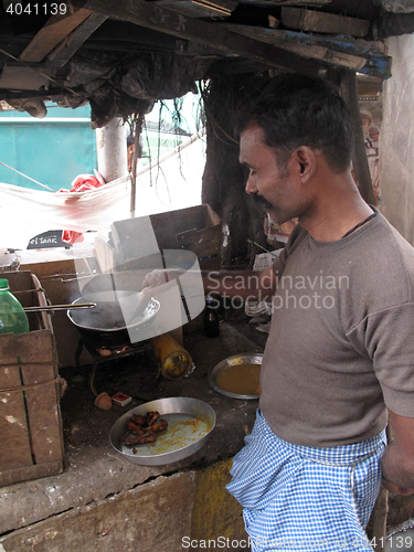 Image of Man cooking on the street in the Chowringhee area of Kolkata, West Bengal, India