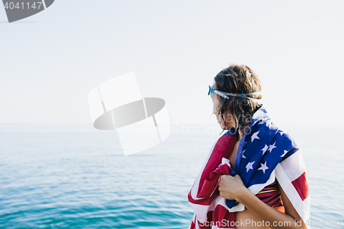 Image of Back view of wet-haired woman in american flag