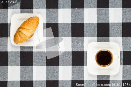 Image of Coffee cup with saucer and croissant