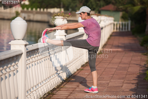 Image of woman  stretching before morning jogging