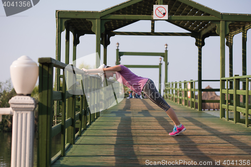 Image of woman  stretching before morning jogging