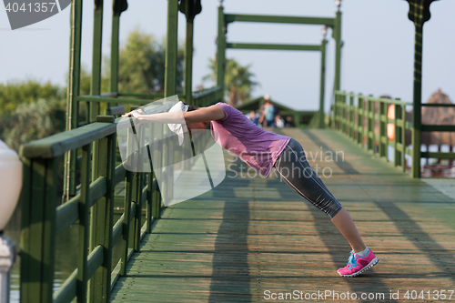 Image of woman  stretching before morning jogging