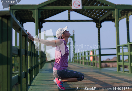 Image of woman  stretching before morning jogging