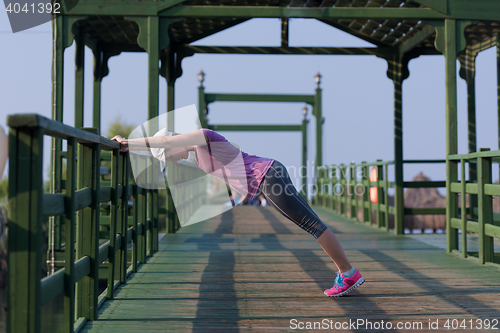 Image of woman  stretching before morning jogging