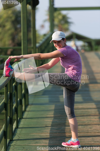 Image of woman  stretching before morning jogging