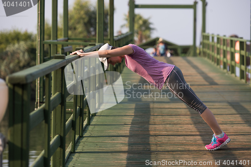 Image of woman  stretching before morning jogging