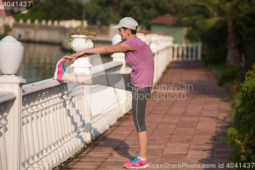 Image of woman  stretching before morning jogging