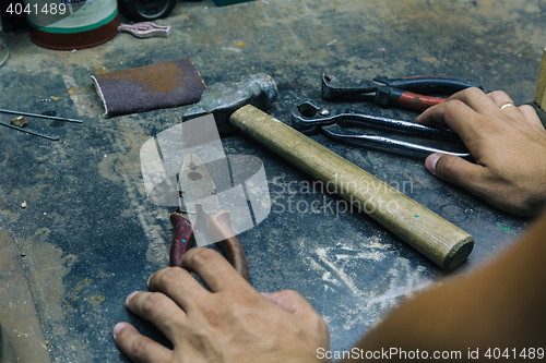 Image of male hands near tools on iron table