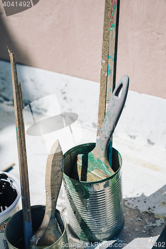 Image of Close-up of brushes in painted cans