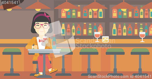 Image of Woman drinking wine at restaurant.