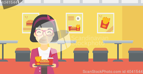 Image of Woman with tray full of fast food.