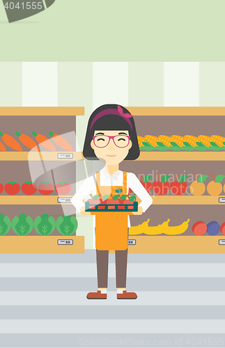 Image of Supermarket worker with box full of apples.