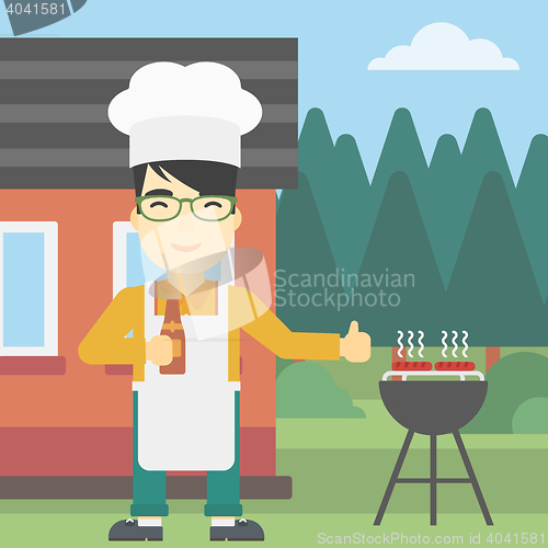 Image of Man cooking meat on gas barbecue grill.