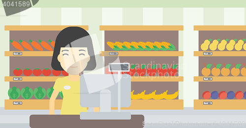 Image of Cashier standing at the checkout in supermarket.