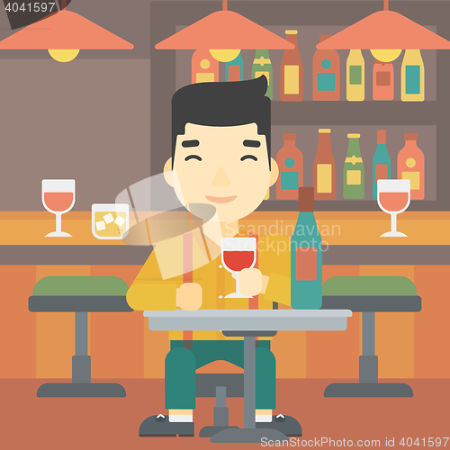 Image of Man drinking wine at restaurant.